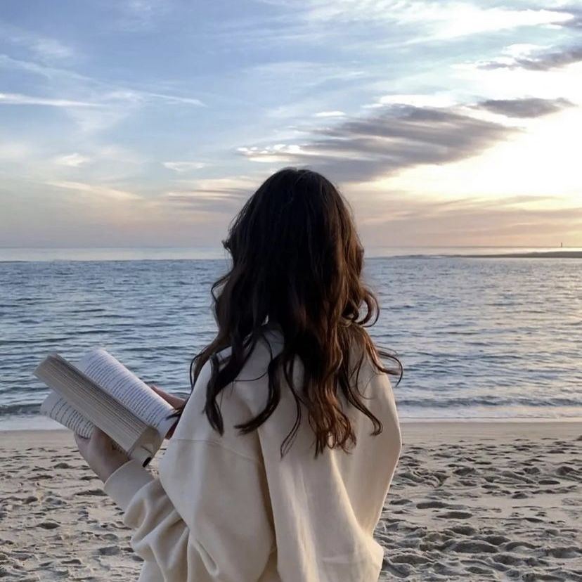 Selma, founder of The French Institute, reading by the sea